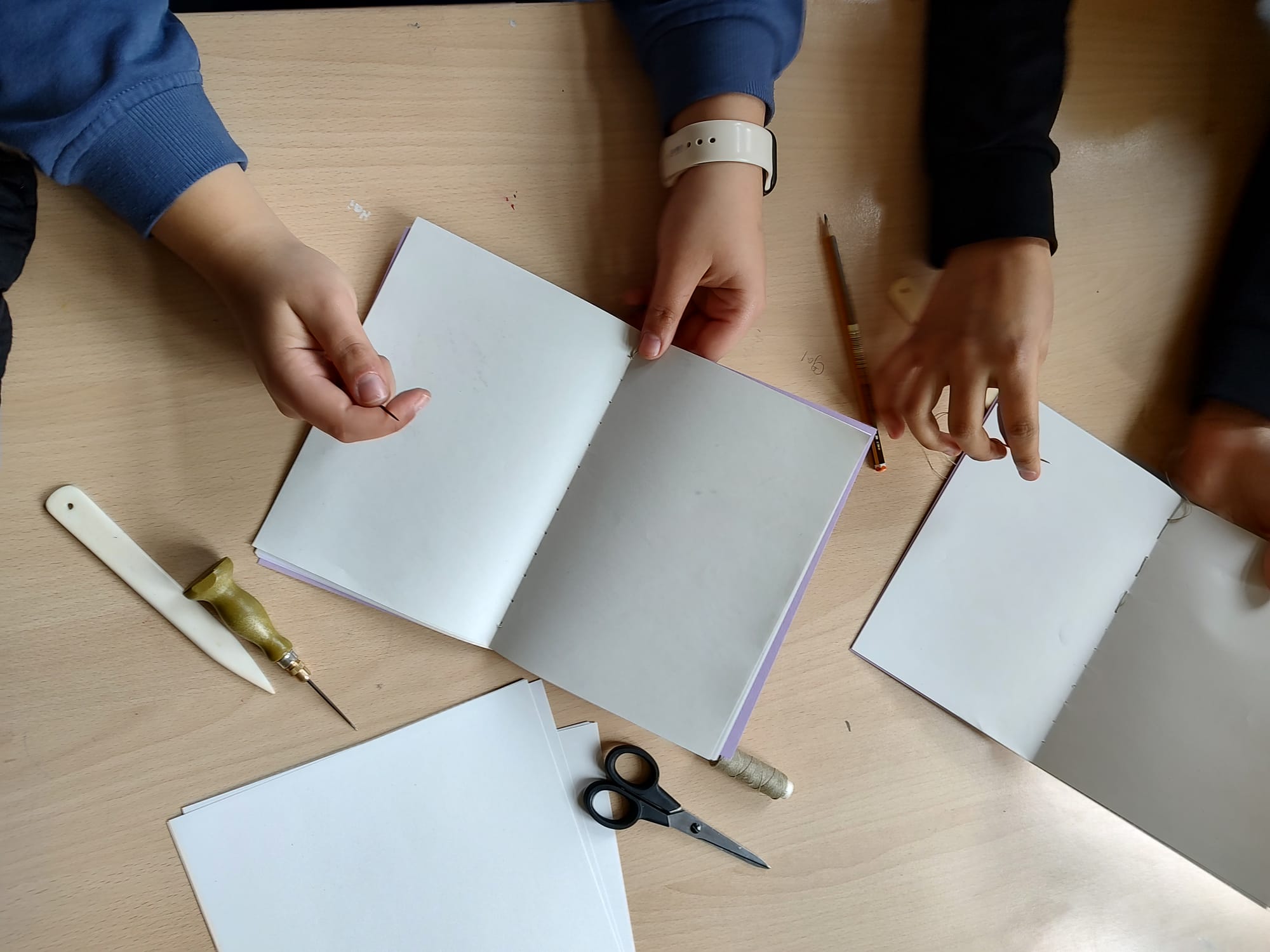 Jugendliche der Kepler-Schule Neukölln beim Erlernen der Fadenheftung im Rahmen eines Workshops am Tag des Buches